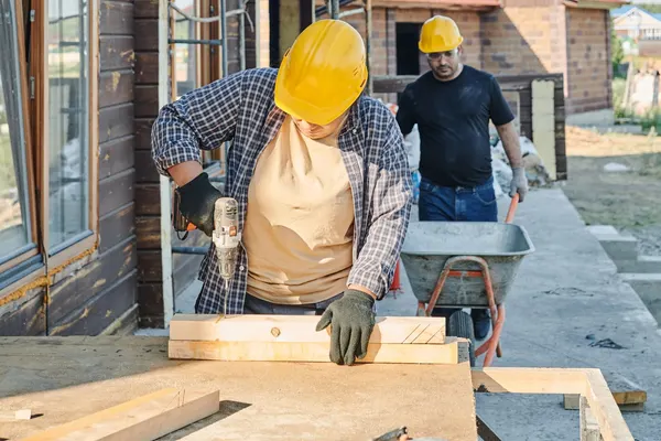 Two tradespeople working on a timber construction project